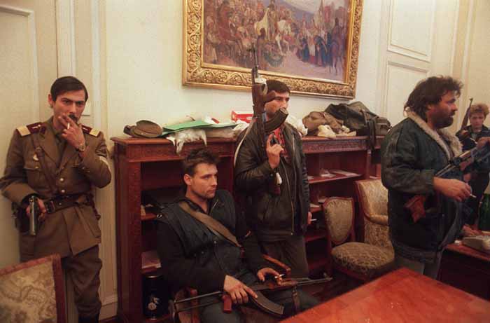 26 دسامبر 1989/ بخارست، رومانی نظامیان و غیر نظامیان در مقر کمیته مرکزی حزب کمونیست رومانی؛ عکس یک روز پس از اعدام نیکلای چاوشسکو و همسرش النا گرفته شده. چاوشسکو رهبر حزب کمونیسم رومانی بود که در بازگشت از سفر به ایران، به دست نیروهای معترض مردمی دستگیر و اعدام شد. انقلاب ضد کمونیستی مردم رومانی به دیکتاتوری 24 ساله چاوشسکو پایان داد / پاتریک هرتزوک / خبرگزاری فرانسه